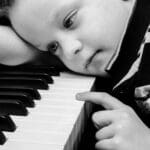 dječak za klavirom, tužan, opterećen