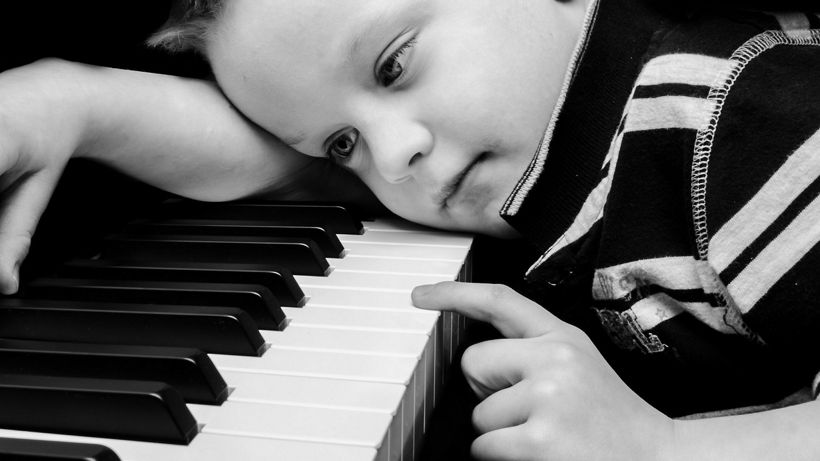 dječak za klavirom, tužan, opterećen