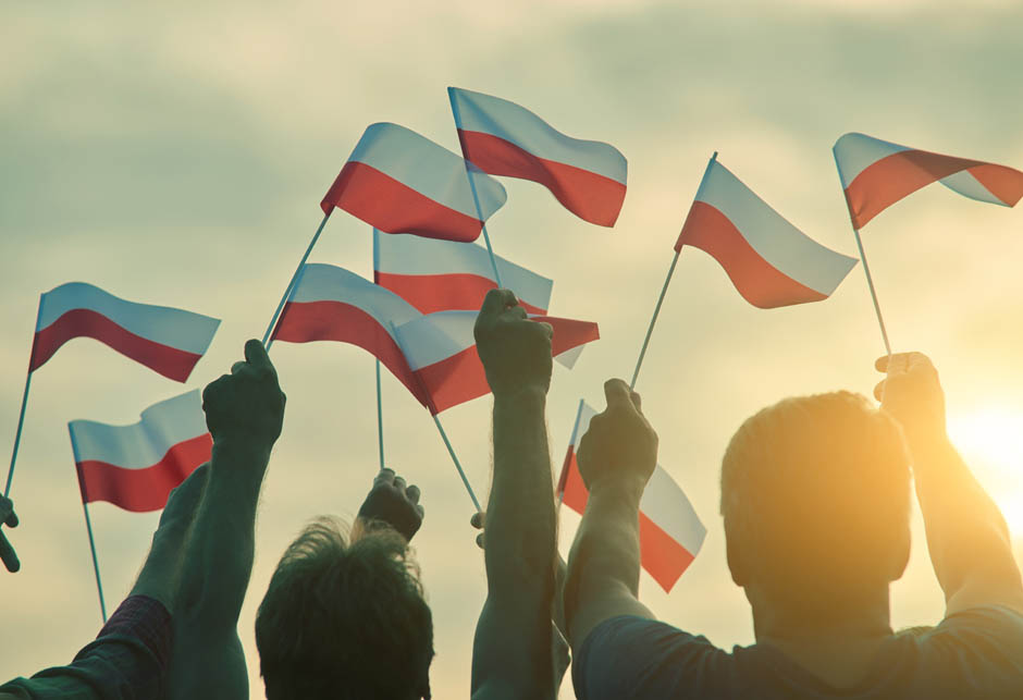 Poland PatriApoljska zastaviceots, Back View. People Raising Polish Flags Up To Th